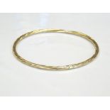 NINE CARAT GOLD BANGLE of twist design, approximately 2.