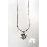 FOURTEEN CARAT WHITE GOLD HEART PENDANT and a fourteen carat white gold chain,