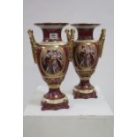 A PAIR OF CONTINENTAL GLAZED PORCELAIN TWO HANDLE URNS of circular tapering outline with flared rim