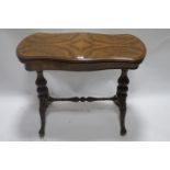 A 19th CENTURY WALNUT VENEERED FOLD OVER TOP GAMES TABLE the rectangular top with bowed sides and