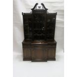 A GEROGIAN STYLE MAHOGANY BREAK FRONT BOOKCASE the broken arched pediment terminating in flower