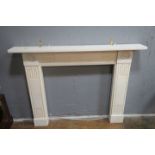 A REGENCY STYLE WHITE MARBLE MANTLEPIECE the rectangular top above the geometric carved jambs