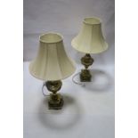 A PAIR OF HEAVY BRASS TABLE LAMPS, each of urn form raised on square stepped base with shades,