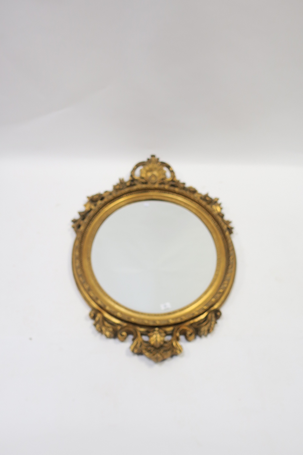 A VICTORIAN GILT FRAMED OVERMANTLE MIRROR the foliate and scrolled cartouche draped with flower