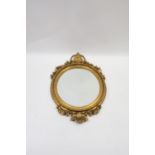 A VICTORIAN GILT FRAMED OVERMANTLE MIRROR the foliate and scrolled cartouche draped with flower