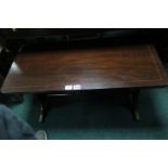 A MAHOGANY COFFEE TABLE, on lyre end supports, splayed legs joined by a cross stretcher,