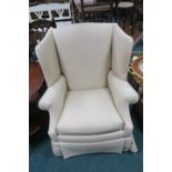 A BEIGE UPHOLSTERED WING CHAIR, with scroll arms and loose cushion.