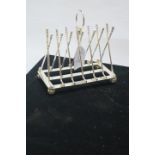 A SILVER PLATED SIX COMPARTMENT TOAST RACK, with golf club uprights, on ball supports.