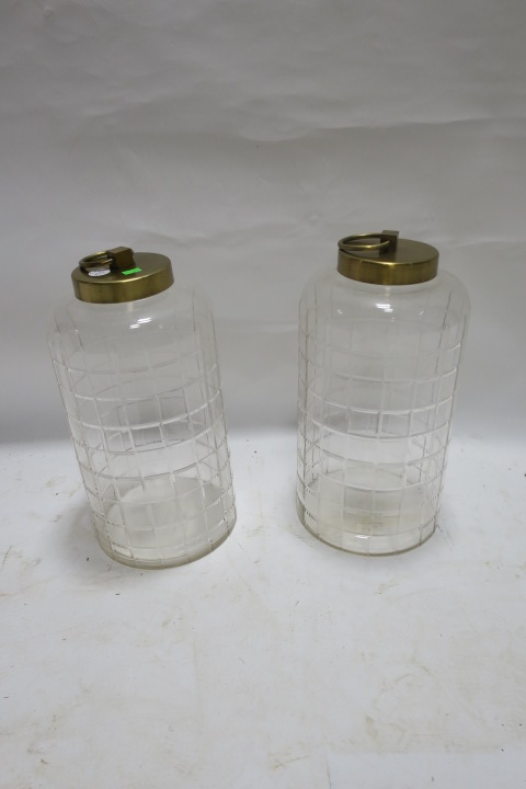 A PAIR OF CUT GLASS STORAGE JARS OF CYLINDRICAL FORM, with brass lids and ring handles, 40cms high.