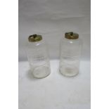 A PAIR OF CUT GLASS STORAGE JARS OF CYLINDRICAL FORM, with brass lids and ring handles, 40cms high.