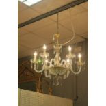 A CUT GLASS FIVE BRANCH CHANDELIER, with scroll arms hung with pendant drops.