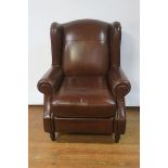 A PAIR OF VICTORIAN STYLE BROWN LEATHER UPHOLSTERED WINGBACK ARMCHAIRS the close upholstered frame