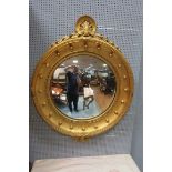 A GEORGIAN STYLE GILT FRAMED CONVEX MIRROR the moulded frame headed by a leaf cartouche with readed