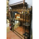 AN EDWARDIAN GOLD PAINTED OVERMANTLE MIRROR the rectangular plate flanked by open shelves between