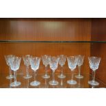 A SET OF ELEVEN WATERFORD CUT GLASS WHITE WINE GLASSES with gilded rims on octagonal tapering stem