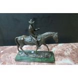 A BRONZE FIGURE OF A COWBOY ON HORSE BACK shown on a rectangular green marble plinth 40cm X 37cm