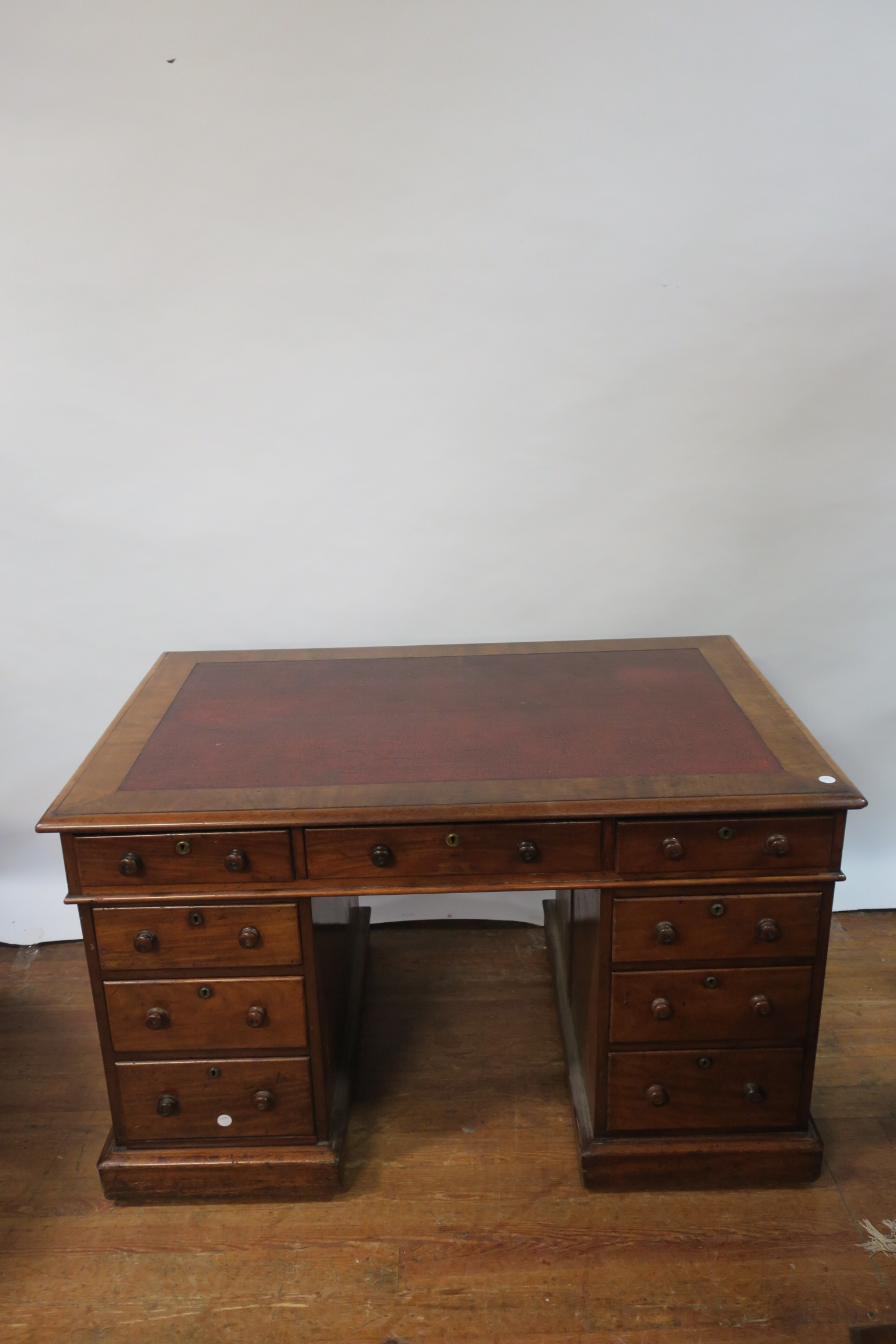 A VICTORIAN MAHOGANY KNEEHOLE DESK the rectangular red leather tooled top with moulded rim above a