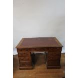 A VICTORIAN MAHOGANY KNEEHOLE DESK the rectangular red leather tooled top with moulded rim above a