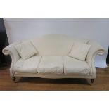 A MAHOGANY FRAMED HUMP BACKED SOFA the cream upholstered back and scrolled sides with loose cushion