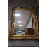 A CONTINENTAL STYLE GILT FRAMED OVERMANTLE MIRROR the rectanglar frame applied with foliate motifs