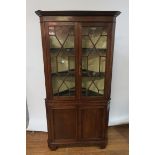 A GEORGIAN STYLE MAHOGANY CORNER CABINET the moulded corners above a plain frieze the pair of