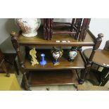 A VICTORIAN MAHOGANY THREE TIER DUMB WAITER each moulded shelf joined by baluster support on brass