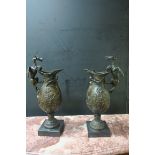 A PAIR OF CONTINENTAL STYLE BRONZED URNS the handle formed as a winged dragon above the body