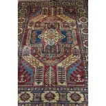 A RECTANGULAR WOOL RUG the beige ground decorated overall with geometric foliate filled panels