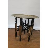 A LATE 19TH CENTURY BURMESE STYLE OCCASIONAL TABLE the engraved brass circular top raised on a ring