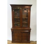 A VICTORIAN MAHOGANY BOOKCASE the moulded cornice above a pair of glazed doors applied with