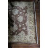 A RECTANGULAR WOOL RUG the gold ground decorated overall with brown and orange foliate motifs with