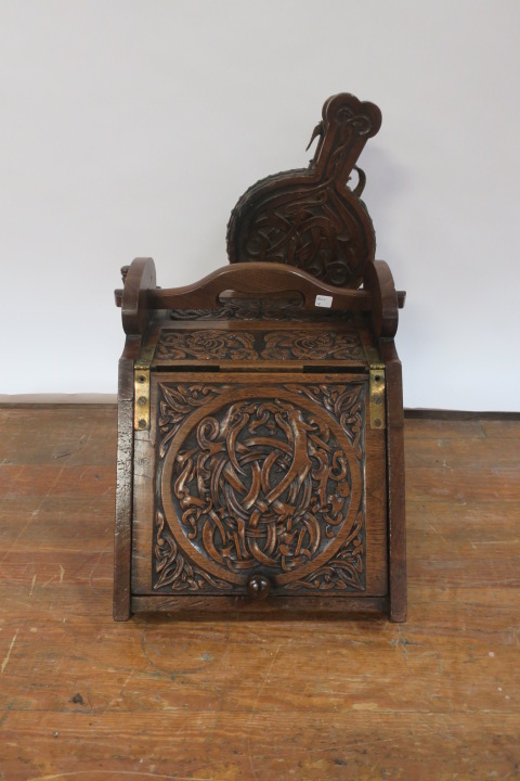 AN EDWARDIAN OAK CARVED COAL SCUTTLE, of rectangular tapering form carved with celtic motifs,