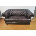 A GOOD HIDE UPHOLSTERED LIBRARY SETTEE, with deep buttoned upholstered back and seat,