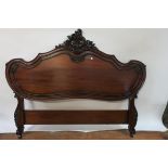 A VICTORIAN STYLE MAHOGANY CARVED HEADBOARD of oval outline the moulded shaped frame headed by a