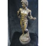 A BRONZE FIGURE, modelled as David, shown standing on a naturalistic base with marble plinth,