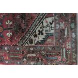 A GOOD ORIENTAL WOOL RUG the light pink ground with central panel filled with palmets,