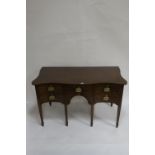 A 19TH CENTURY MAHOGANY SERPENTINE SHAPED SIDEBOARD the top with satinwood border above a central