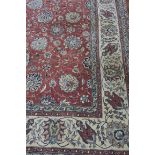 A RECTANGULAR WOOL RUG the rose coloured central panel filled with flower heads and trailing