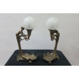 A PAIR OF ART NOUVEAU STYLE TABLE LAMPS in the form of a female above a shaped base with frosted