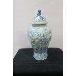 AN ORIENTAL STYLE BLUE AND WHITE GLAZED PORCELAIN URN AND COVER, of tapering octagonal form,