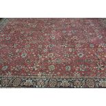 A RECTANGULAR WOOL RUG, the orange ground decorated overall with foliate motifs and vines,