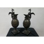 A PAIR OF CONTINENTAL STYLE BRONZED URNS the handle formed as a winged dragon above the body