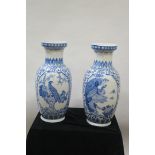 A PAIR OFORIENTAL STYLE BLUE AND WHITE GLAZED VASES OF CIRCULAR TAPERING FORM decorated with birds