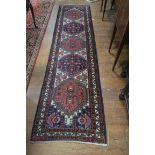 A PERSIAN WOOL MESHKIN RUNNER, the white indigo and rust ground with central diamond panels,