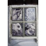 A Victorian four pane sash window with black and white images of Simon's outside cottages and