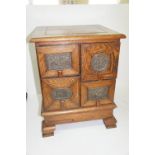 An early 20thC oak four drawer trinket chest with panel sides on bracket feet, the drawers having