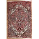Persian Heriz Carpet, red ground, central medallion and spandrels, repeating floral border, 7 ft.