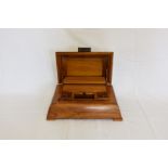 An Art Deco style desk top stationery box with two inkwells, central compartment and paper knife.