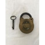 A brass wrought iron Bramah padlock and key, the lock plate with sliding brass top section