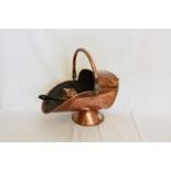 A copper coal scuttle with swing handle together with its shovel with ebonised handle. Est £15-30